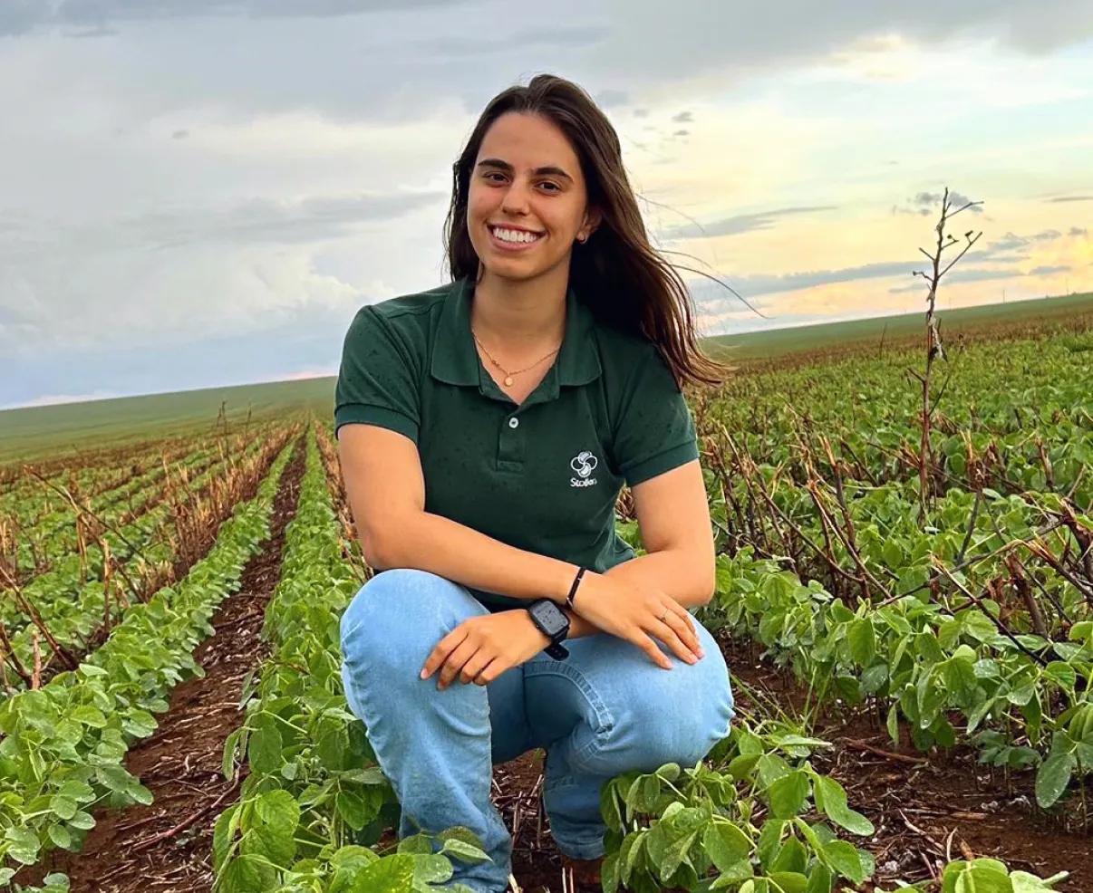 Jovem segurando um flor em um campo